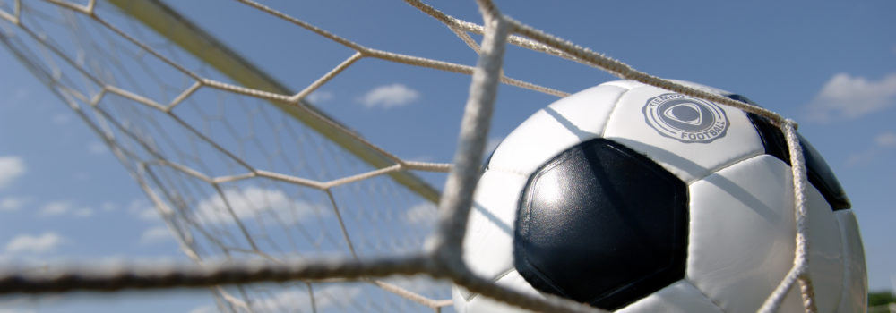 football - soccer ball in goal Football - soccer ball in goal against blue sky